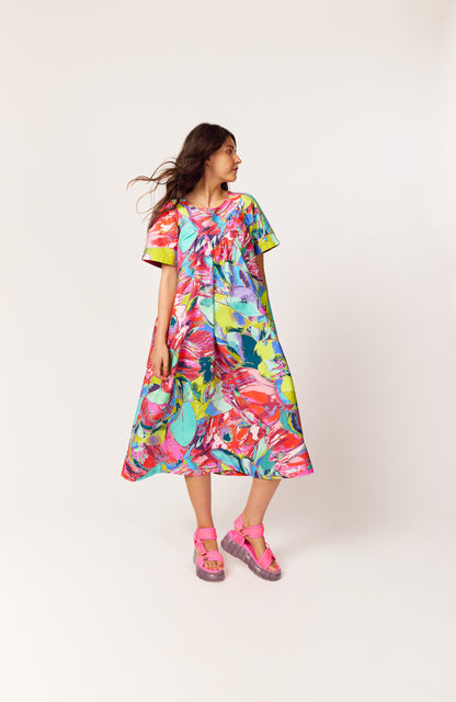 Side angle of The Debut Dress in the multicoloured, vibrant, Protea Painterly print – sustainable floral midi dress with roomy pockets.